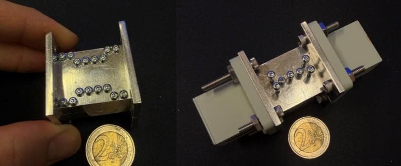 Compact tunable Locally Resonant Metamaterial filter for X/Ku band, held in hand and on the bench, next to a 2-euro coin